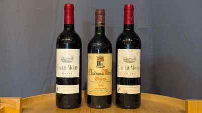 three bottles of wine are sitting on a wooden tray