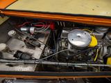 a small engine in the trunk of an orange car