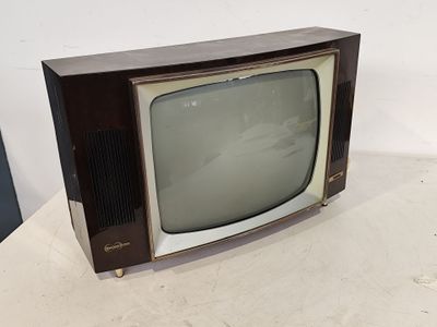 a small television sitting on a table with a white wall in the background