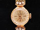 a close up of a gold watch with diamonds on it