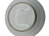 a white plate with a brown rim on a white surface