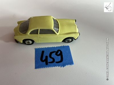 une petite voiture jaune posée à côté d'une feuille de papier bleue