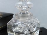 a clear glass perfume bottle sitting on top of a book