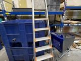 une photo d'une échelle dans un entrepôt avec des cartons