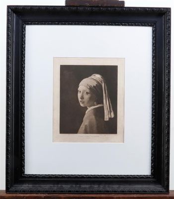 an old black and white photo of a girl with a pearl ear