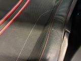 a close up of a car seat with red stitching