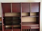 an empty room with a desk, shelves, and cabinets