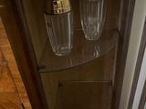 a glass shelf with two empty bottles on top of it