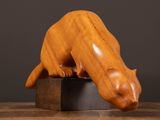 a wooden sculpture of a cat sitting on top of a wooden block
