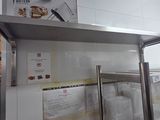 stainless steel shelvings in a commercial kitchen with a ladder in the background