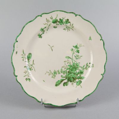 une assiette verte et blanche décorée de fleurs et de feuilles