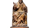 a statue of a man sitting on top of a table