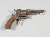 un vieux pistolet avec une poignée en bois sur une surface blanche