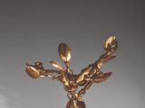 a gold vase that has a bunch of flowers on it