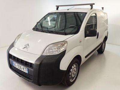 une camionnette blanche aux finitions noires garée dans une pièce blanche