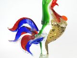 un coq en verre posé sur un socle en verre
