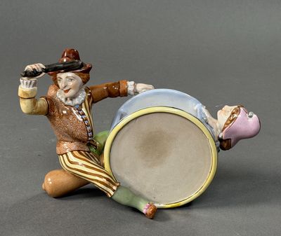 a figurine of a man sitting on the ground with a drum