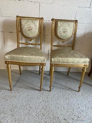pair of gold painted chairs with floral upholstered seats