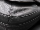 close up of a black leather purse with a zipper on the side
