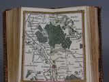 an old book with a map on it sitting on a table