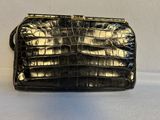 un sac à main en cuir de crocodile noir sur fond blanc