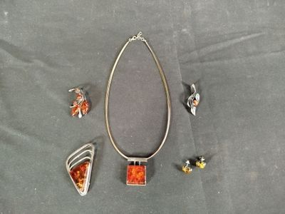 Plusieurs bijoux sont disposés sur une surface grise