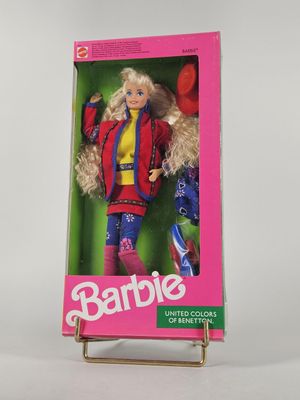 La poupée Barbie se trouve dans une boîte rose posée sur une surface blanche.
