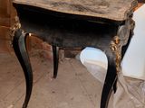 a black table with a marble top in a room with a brick wall