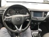 someone is sitting in the driver ' s seat of a car with their feet on the steering wheel