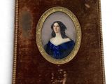Une vieille photo d'une femme en robe bleue est accrochée au mur.