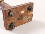 a small wooden object that is sitting on a white surface
