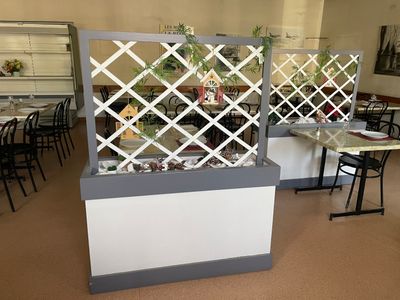une pièce avec des tables et des chaises, et une jardinière au centre