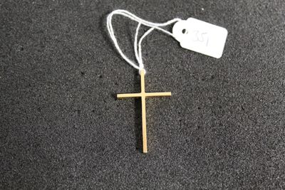 une croix posée par terre, avec une étiquette de prix accrochée dessus