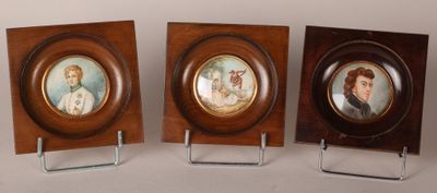 Trois portraits encadrés représentant un homme et une femme sont exposés
