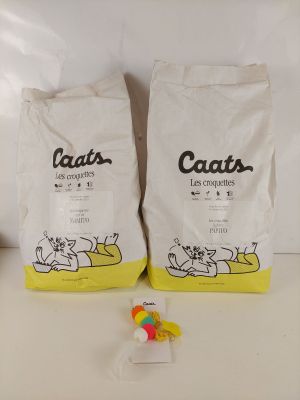 deux sacs de litière pour chat posés sur un plan de travail blanc