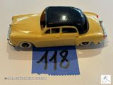 une petite voiture jaune posée sur une feuille de papier bleue