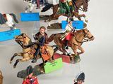 many figurines of people riding horses on display