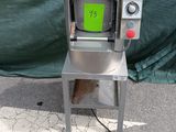 une machine posée par terre, sur laquelle est apposé un autocollant vert