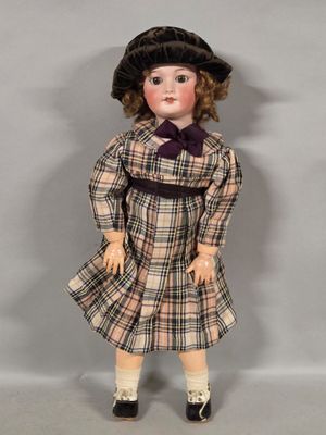an image of a doll wearing a dress and a hat