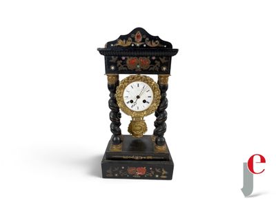 a black and gold clock sitting on a white surface
