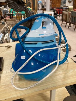 un fer à repasser à vapeur bleu et blanc posé sur une table