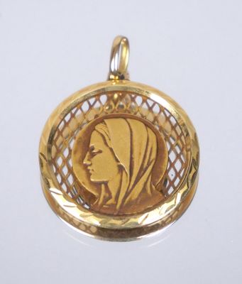 une image représentant un pendentif en or avec le visage d'une femme au centre
