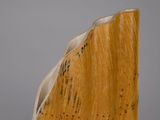sculpture représentant un serre-livres en bois posé sur une surface blanche, avec un fond gris