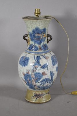 un vase bleu et blanc auquel est attaché un cordon jaune