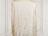 an image of a white shirt on a mannequin stand in front of a wall