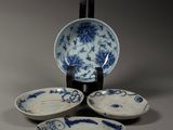 three blue and white plates and a bowl on a stand