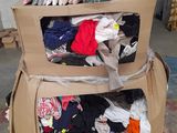 two boxes with clothes on top of them in a warehouse