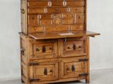 une vieille commode en bois avec de nombreux tiroirs, surmontée d'autres tiroirs