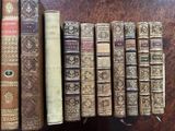 several old books are lined up on a shelf in a library