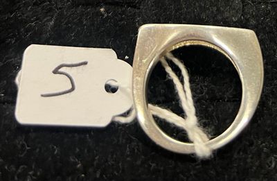une bague en argent avec une plaquette sur laquelle est inscrit le chiffre 5